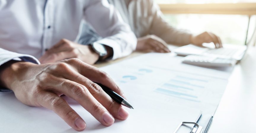 Man holding a pen going over market trends